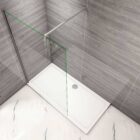 Minimalist walk-in wetroom with a single glass panel and robust support bar for a clean, open feel. MLH Products.